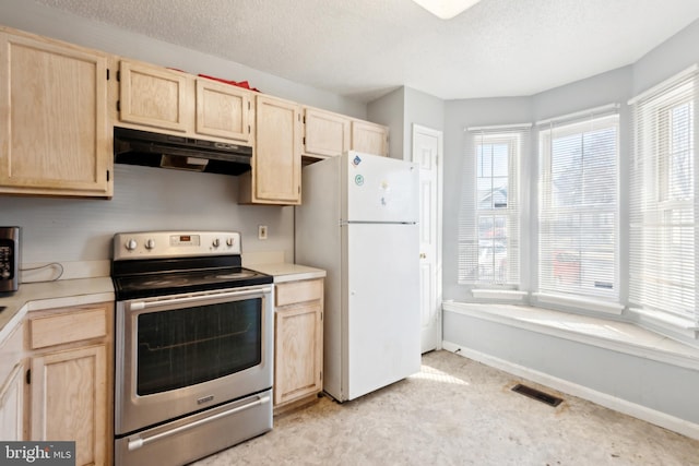 kitchen with under cabinet range hood, visible vents, light brown cabinets, and appliances with stainless steel finishes