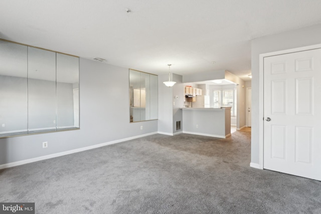 unfurnished living room featuring carpet floors, baseboards, and visible vents