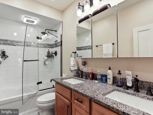 full bathroom with enclosed tub / shower combo, vanity, and toilet