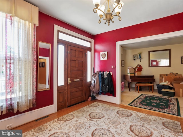 foyer with a chandelier, wood-type flooring, and a wealth of natural light