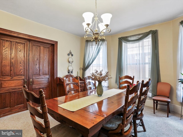 carpeted dining space with a notable chandelier