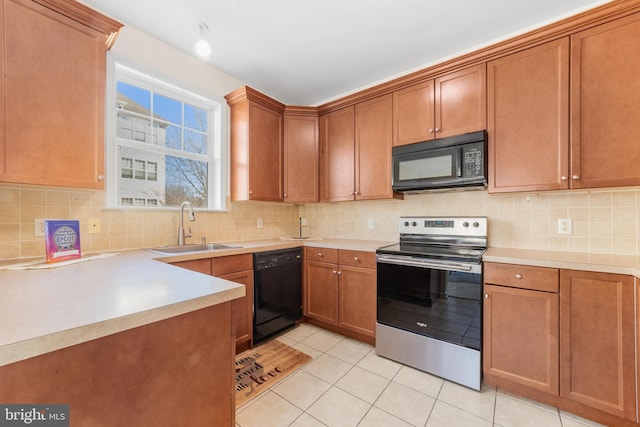 kitchen with black appliances, backsplash, light tile patterned flooring, and a sink