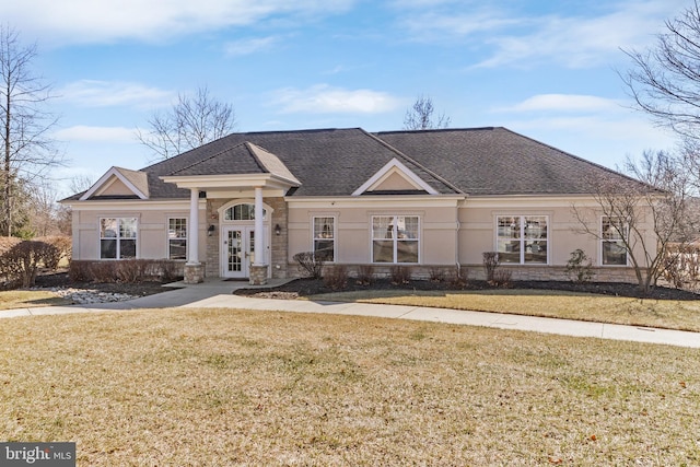 view of front facade featuring french doors, a front lawn, and a shingled roof