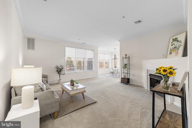 living room with a chandelier, a premium fireplace, carpet flooring, visible vents, and crown molding