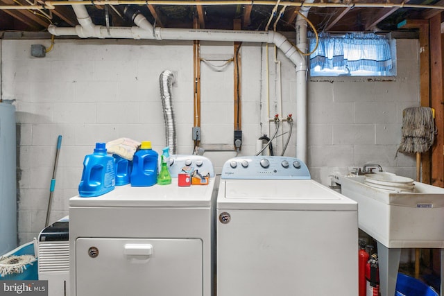 clothes washing area featuring laundry area, a sink, and separate washer and dryer