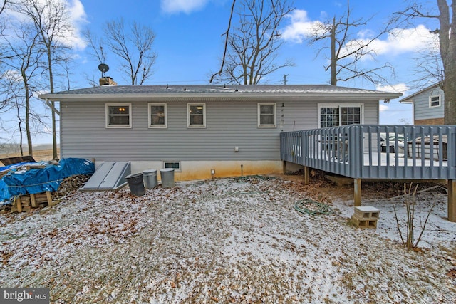 snow covered rear of property featuring a deck