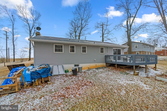 rear view of property with a chimney and a deck