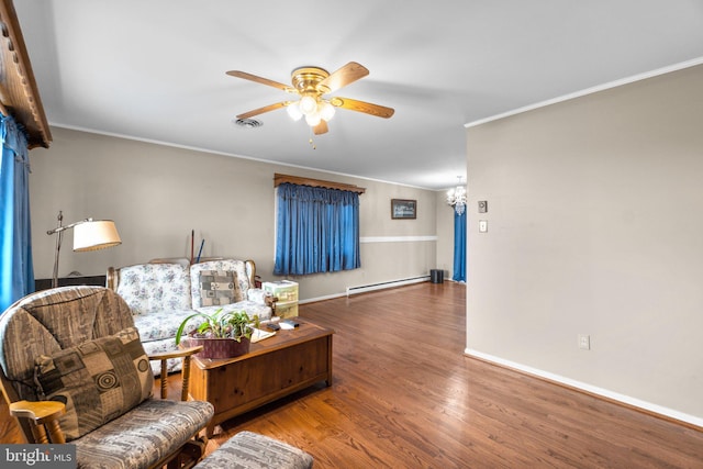 living room featuring ornamental molding, a baseboard heating unit, ceiling fan, wood finished floors, and baseboards