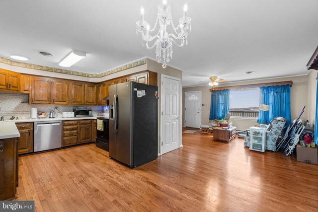 kitchen featuring visible vents, brown cabinetry, appliances with stainless steel finishes, light countertops, and light wood-type flooring