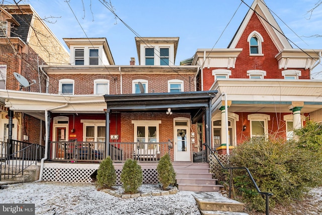 multi unit property featuring covered porch and brick siding