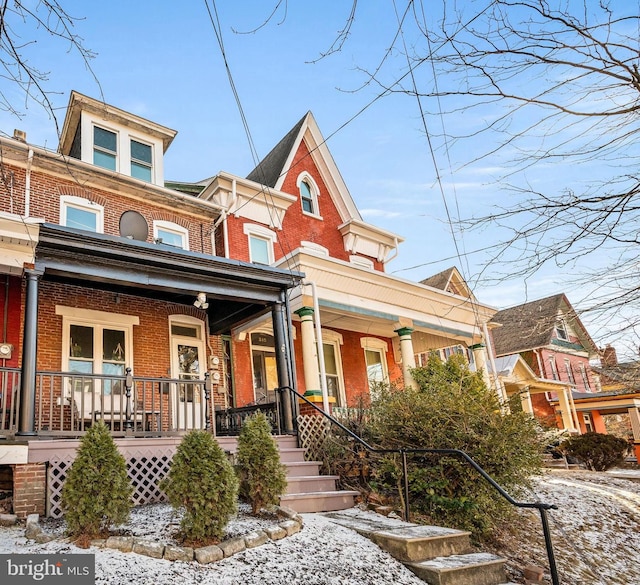 view of front of home featuring a porch and brick siding