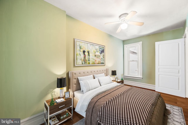 bedroom with a ceiling fan, baseboards, and wood finished floors