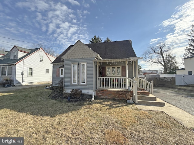 view of front of house featuring covered porch and a front yard