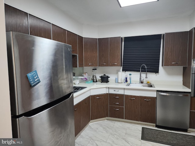 kitchen with appliances with stainless steel finishes, sink, and dark brown cabinets