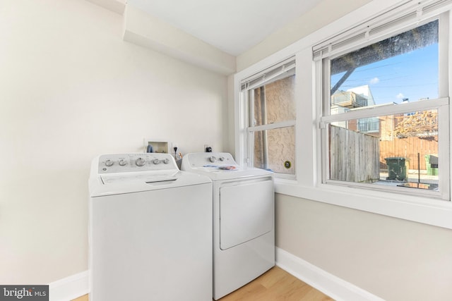 laundry room with separate washer and dryer and light wood-type flooring