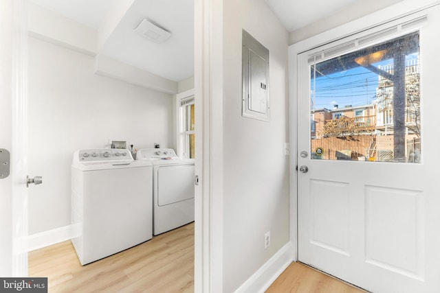 washroom featuring washer and dryer, electric panel, and light hardwood / wood-style floors