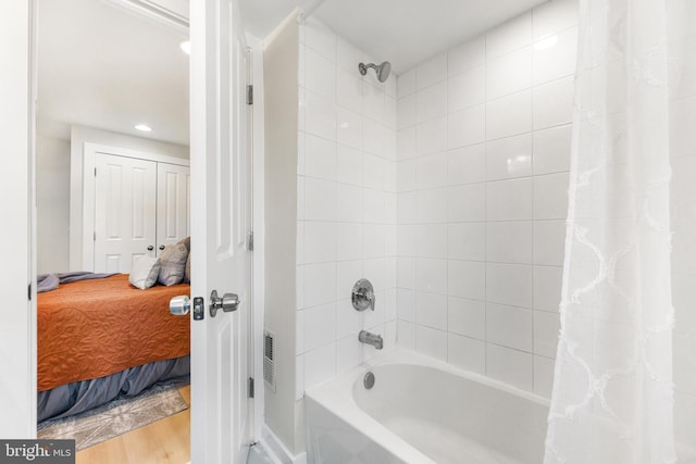 bathroom featuring shower / bath combination with curtain and hardwood / wood-style floors