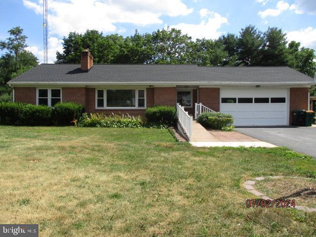 single story home with a garage and a front yard