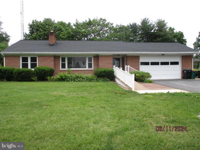 single story home featuring a garage and a front yard