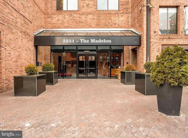 entrance to property featuring brick siding