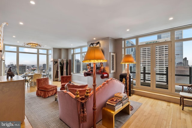 living room featuring expansive windows, plenty of natural light, and light hardwood / wood-style floors