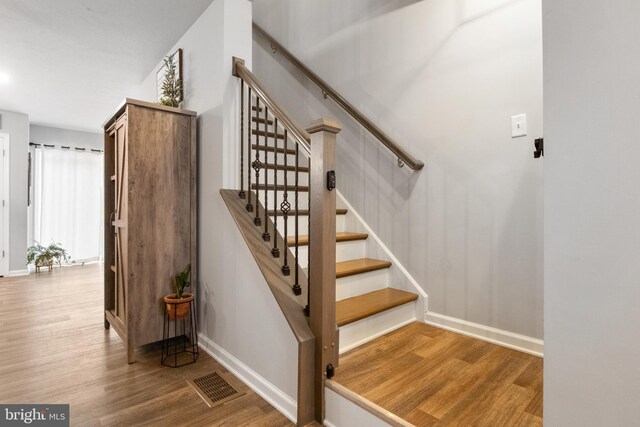 stairs featuring hardwood / wood-style flooring