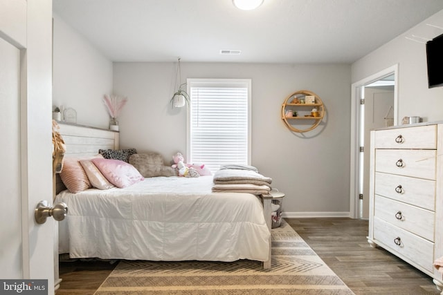 bedroom with dark hardwood / wood-style floors