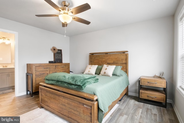 bedroom featuring ceiling fan, wood-type flooring, connected bathroom, and sink