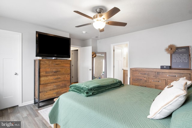 bedroom with ceiling fan, ensuite bathroom, and light hardwood / wood-style floors