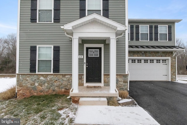 snow covered property entrance with a garage