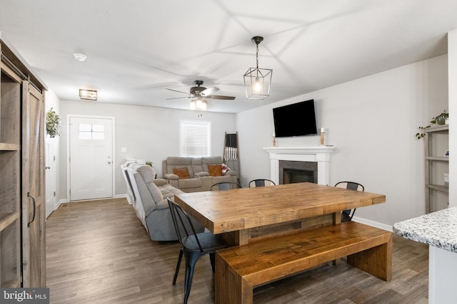 dining area with ceiling fan and dark hardwood / wood-style flooring