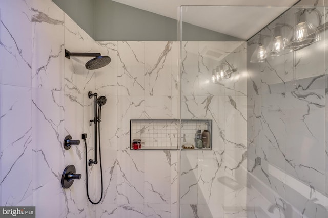 bathroom featuring lofted ceiling and a marble finish shower