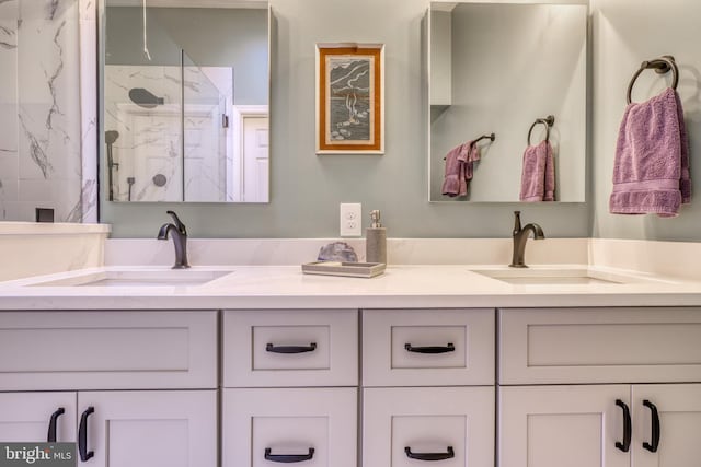 full bath with double vanity, a sink, and a marble finish shower