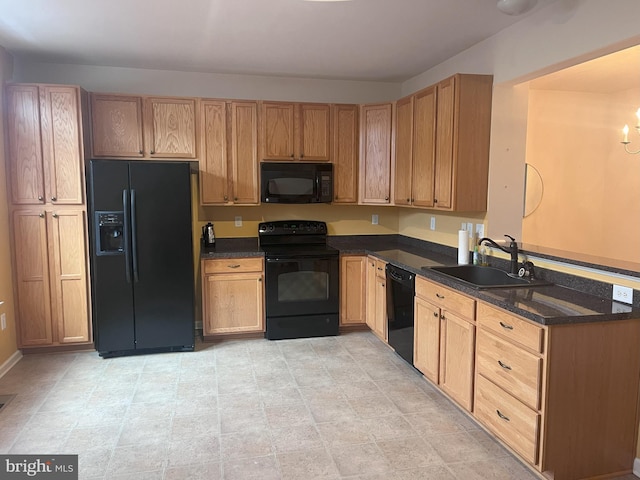 kitchen featuring dark stone countertops, sink, and black appliances