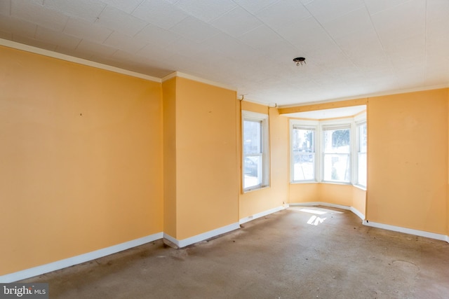 empty room featuring baseboards and ornamental molding