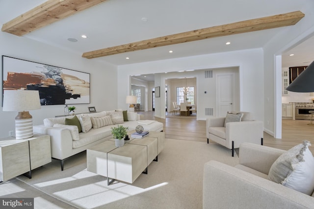 living area with visible vents, light wood finished floors, beam ceiling, and recessed lighting