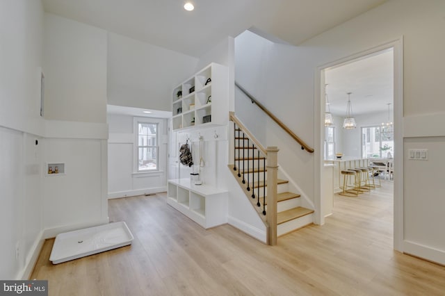 entryway featuring light wood-type flooring, a healthy amount of sunlight, and stairway