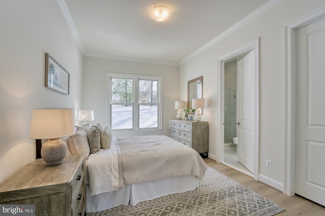 bedroom with connected bathroom, baseboards, crown molding, and light wood finished floors