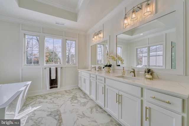 bathroom featuring double vanity, marble finish floor, ornamental molding, and a sink