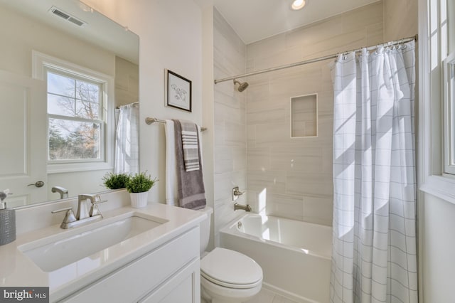 bathroom featuring toilet, shower / tub combo, vanity, and visible vents