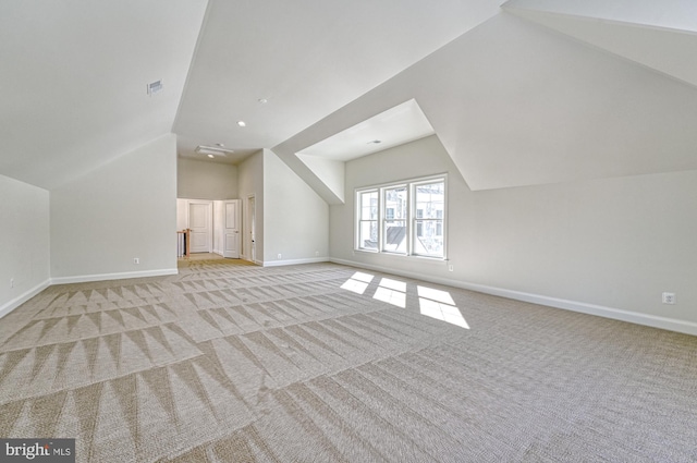 additional living space with baseboards, vaulted ceiling, and light colored carpet