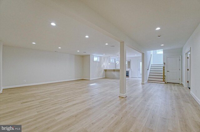 basement featuring baseboards, stairway, recessed lighting, and light wood-style floors