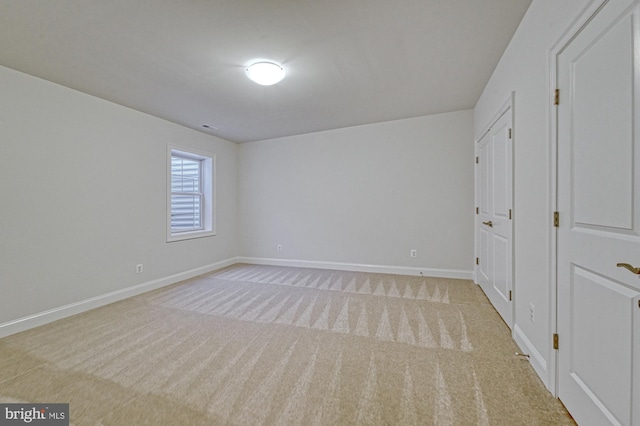 unfurnished bedroom with baseboards and light colored carpet