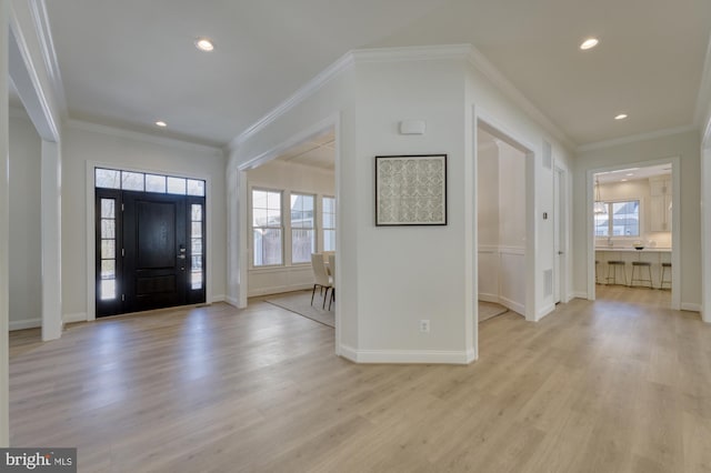 entrance foyer with recessed lighting, baseboards, crown molding, and light wood finished floors