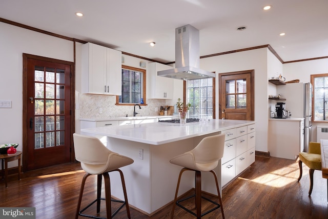 kitchen featuring light countertops, a center island, white cabinets, and island exhaust hood