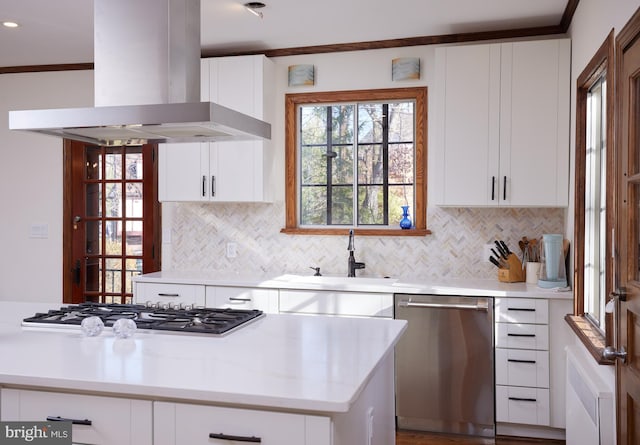 kitchen with stainless steel appliances, light countertops, island exhaust hood, and white cabinetry