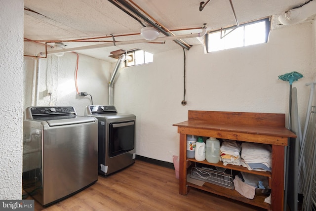 washroom featuring laundry area, separate washer and dryer, plenty of natural light, and light wood-style flooring