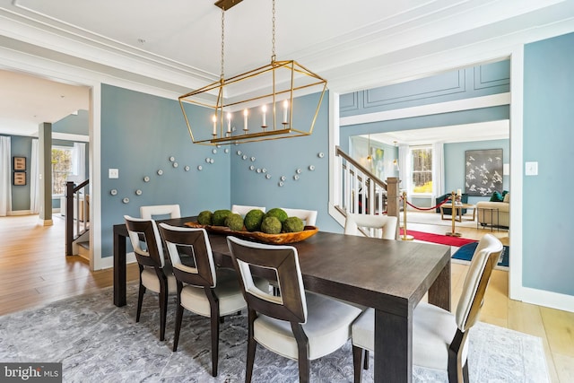 dining space with an inviting chandelier, hardwood / wood-style floors, crown molding, and a wealth of natural light