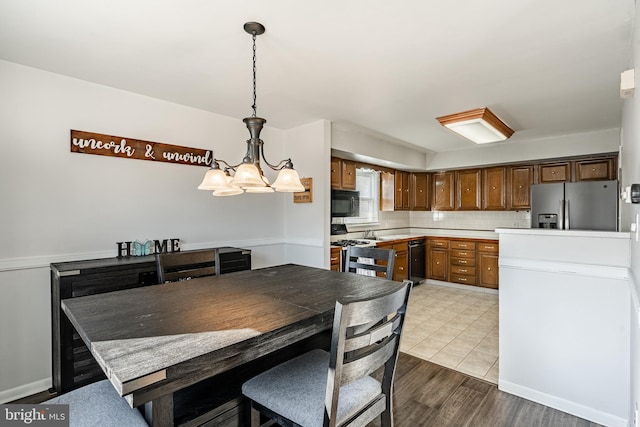 dining space featuring wood finished floors and an inviting chandelier