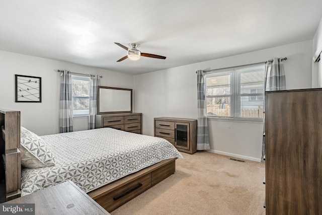 bedroom with baseboards, visible vents, a ceiling fan, and light colored carpet